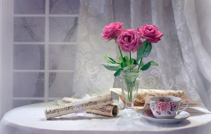 Still-life with pink roses, teacup, and sheet music