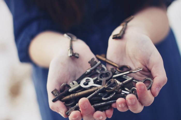 Hands holding a pile of old keys