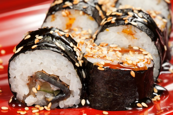 Sushi rolls with sesame seeds and sauce