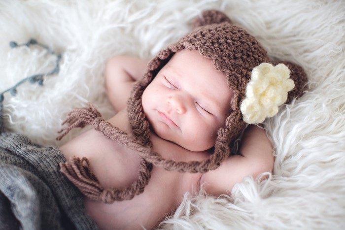 Baby sleeping in a brown knitted hat