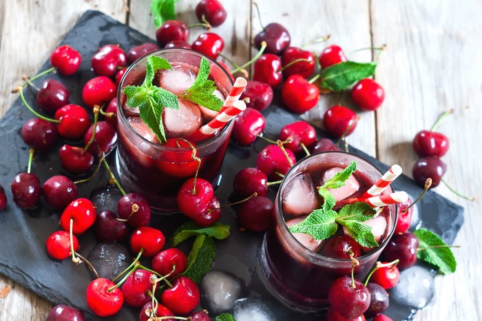 Two glasses of cherry drink with ice and mint