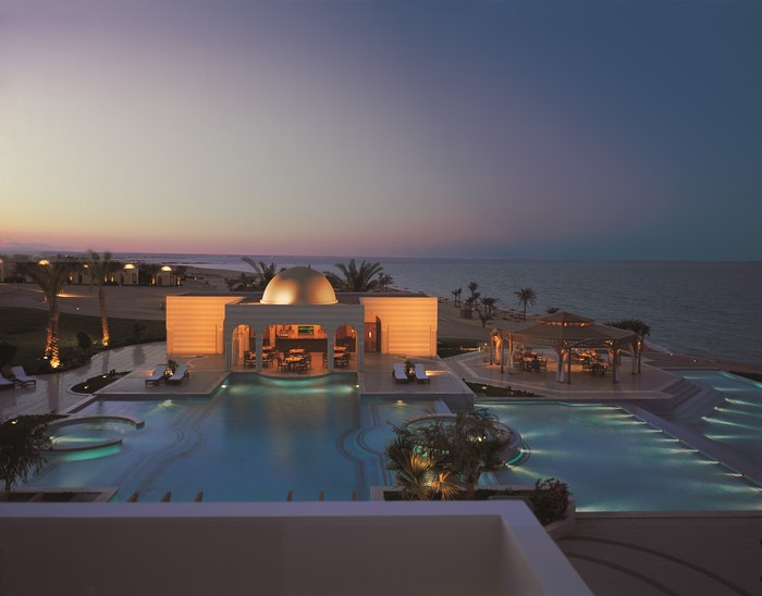 Resort with pools and sea at dusk