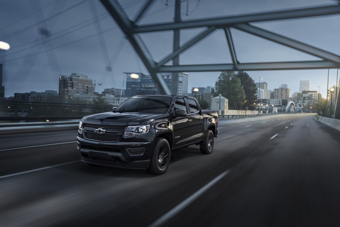 Black Chevrolet Colorado Midnight Crew Cab driving on a bridge