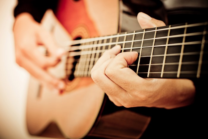 Closeup of hands playing a guitar