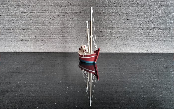 Wooden toy sailboat with reflection