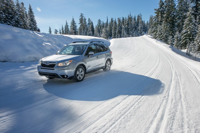 Silver Subaru Forester driving on a snowy road