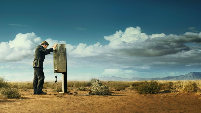 Man in suit at payphone in desert