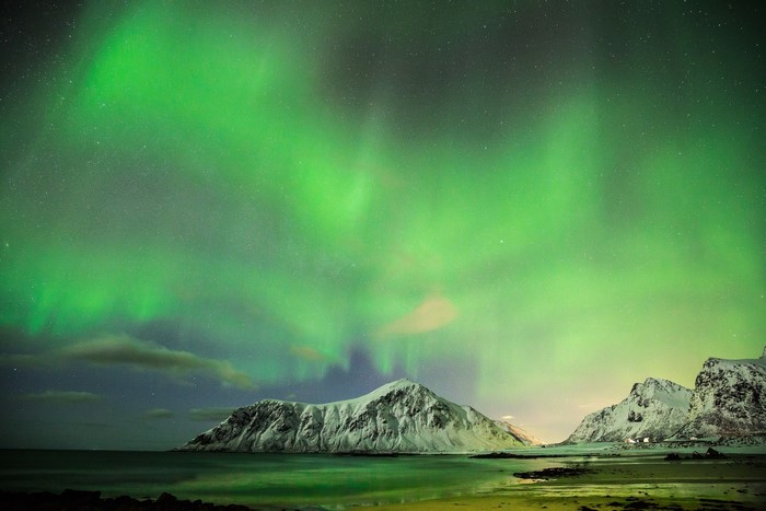 Aurora Borealis over snowy mountains in Norway