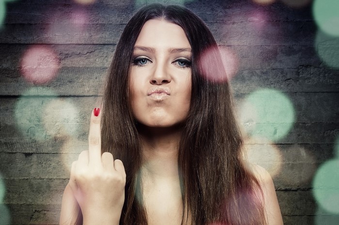 Woman with brown hair showing middle finger