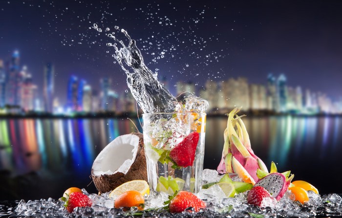 Cocktail with Fruits and Water Splash in City Night