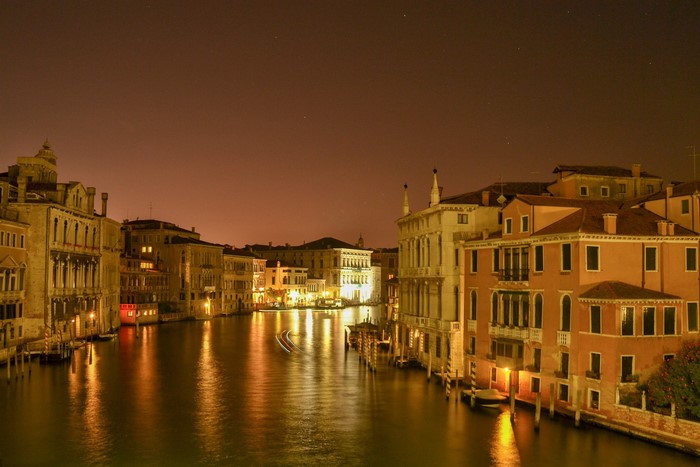 Venice canal at night with illuminated buildings