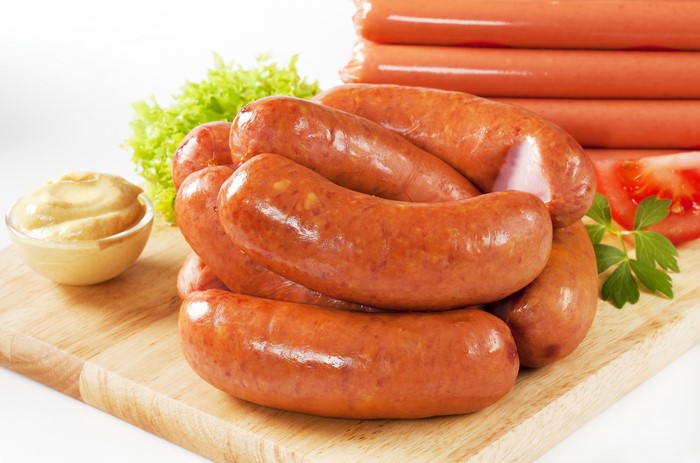 Sausages with mustard, lettuce, and tomato