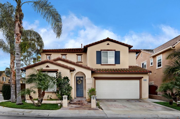 Two-story house with palm trees and blue shutters