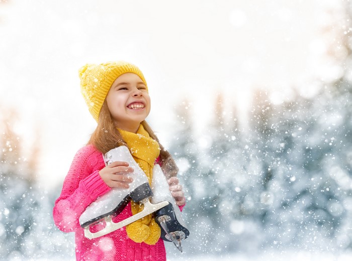 Girl in Winter Hat Holding Ice Skates