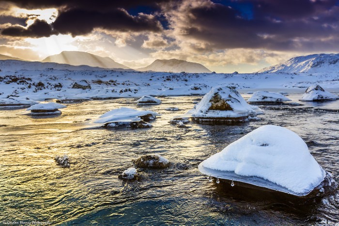 Winter River with Snow-Covered Rocks and Mountains