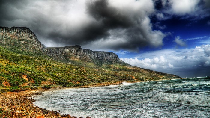 Rocky Coastline with Craggy Mountains and Stormy Clouds