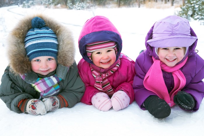 Three Children in Winter Clothing Smiling in Snow