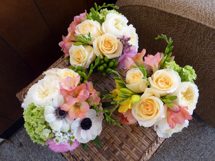 Three bouquets of roses, anemones, and freesia
