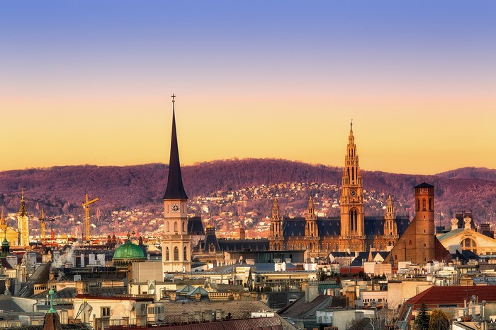 Vienna cityscape with churches and mountains at sunset