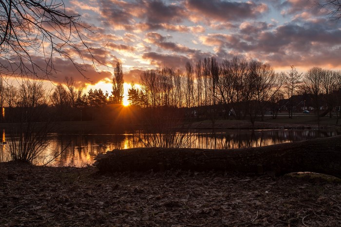 Sunset over a lake with trees and clouds