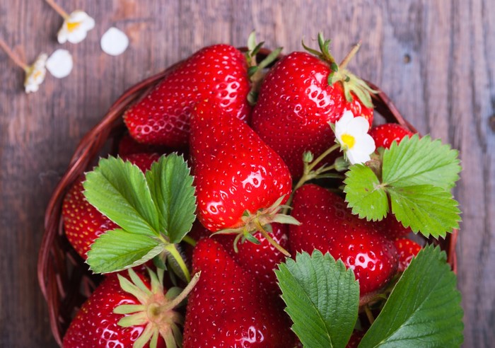 Basket of Strawberries with Leaves and Flowers