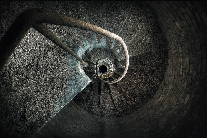 Spiral staircase in a dark, abandoned well