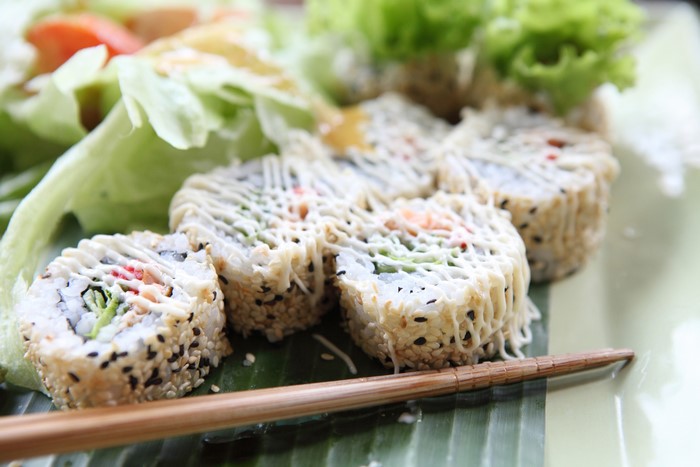 Sushi rolls with salad and chopsticks