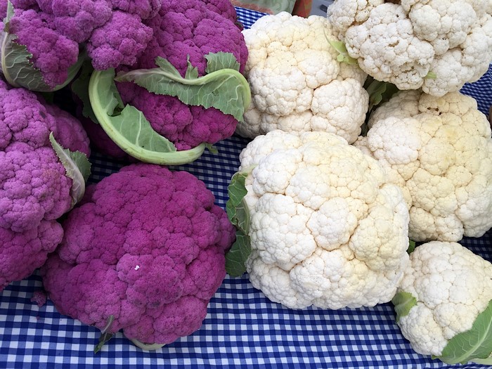 Purple and white cauliflower on a blue checkered tablecloth