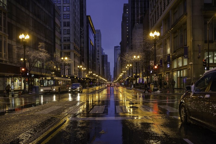 Chicago street at night with wet roads and streetlights