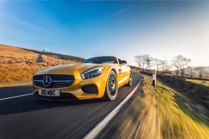 Yellow Mercedes-Benz AMG GT S driving on a road