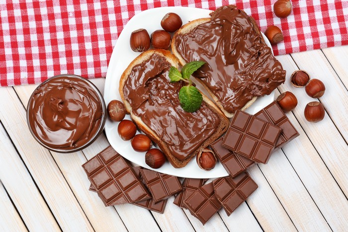 Chocolate spread on toast with hazelnuts and chocolate bars
