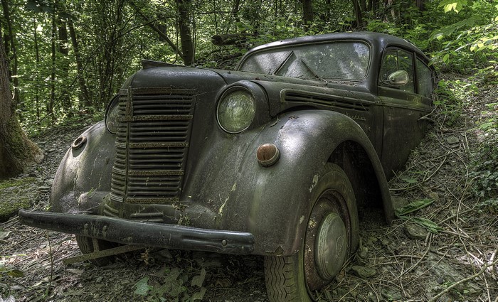 Abandoned vintage car in a forest
