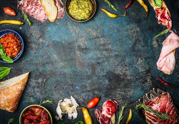 Meat products and bread with dips and peppers