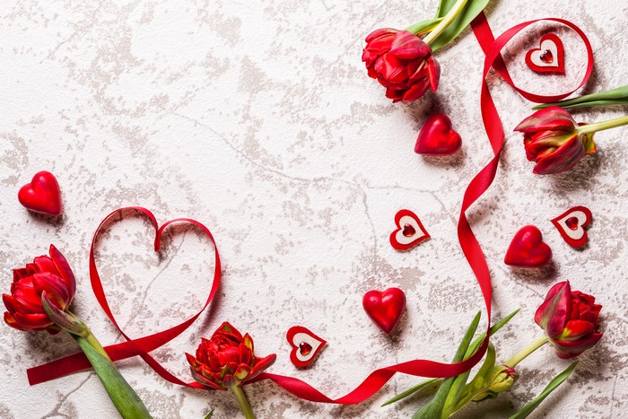 Red Tulips and Hearts with Ribbon on Textured Background