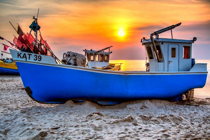 Fishing boats on a beach at sunset