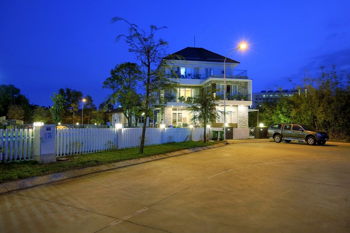 Modern house at night with street lights and a truck