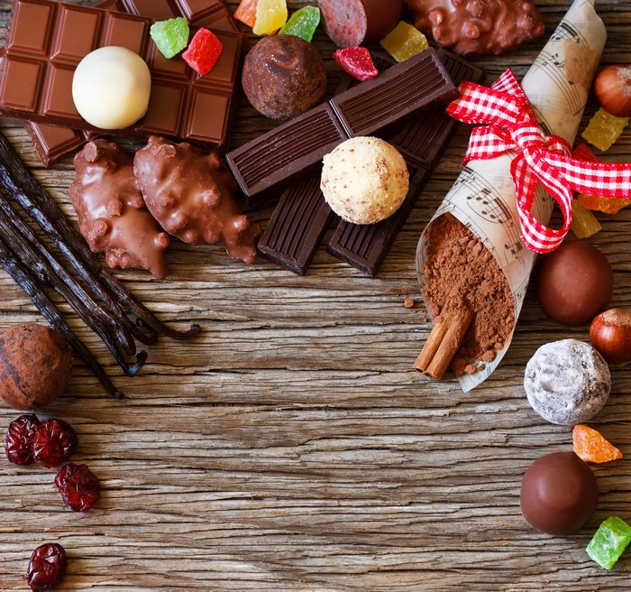 Chocolate bars, truffles, and candies on wooden table