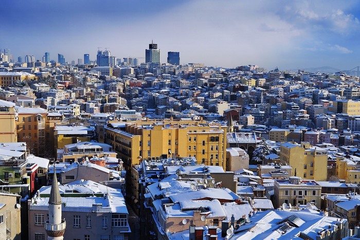 Istanbul cityscape covered in snow under a blue sky