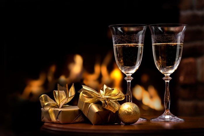 Champagne glasses and gifts by a fireplace