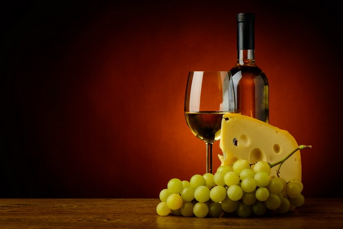 Wine bottle, glass, cheese, and grapes