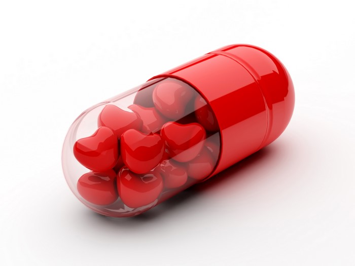 Red capsule filled with heart-shaped candies
