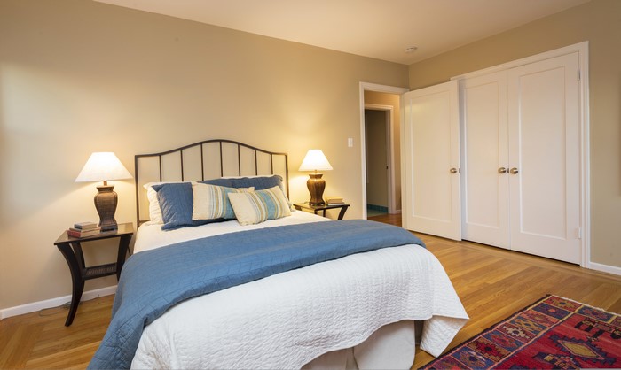 Bedroom with bed, lamps, and closet