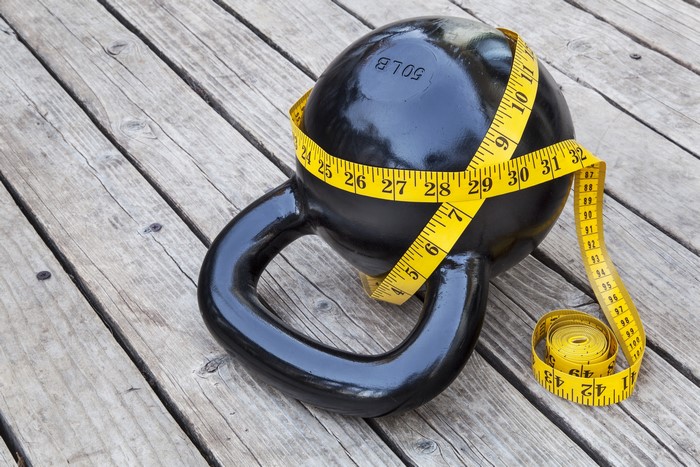 Kettlebell with Measuring Tape on Wood Planks