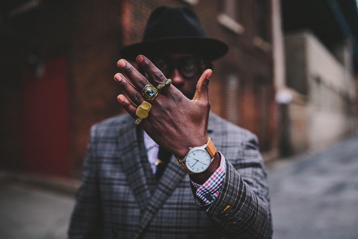 Man wearing a hat, suit, and rings