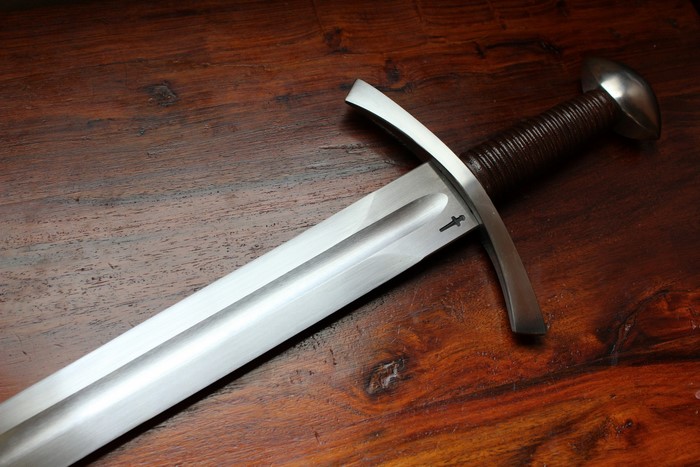 Close-up of a medieval sword on a wooden table