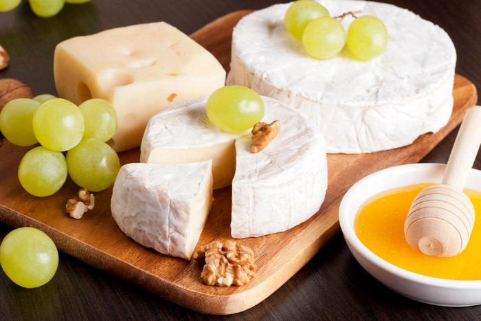 Cheese, Grapes, Nuts, and Honey on a Wooden Board