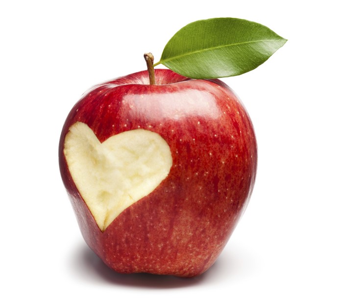 Red apple with heart carved out and leaf