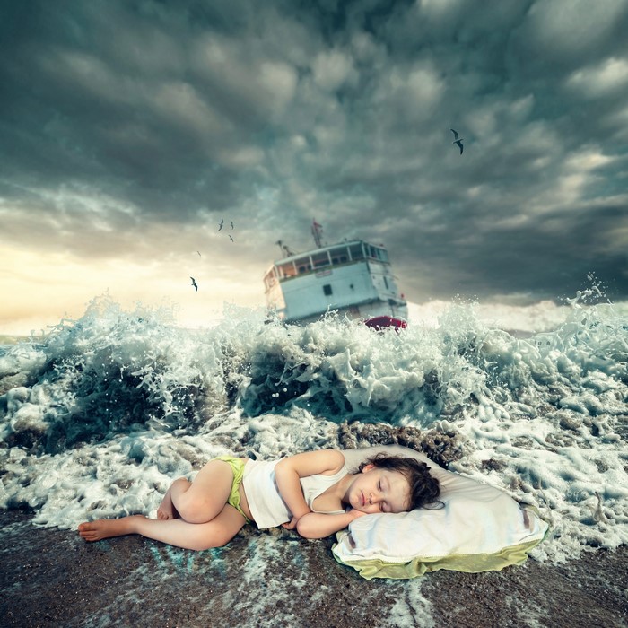 Girl sleeping on a pillow in stormy seas with a ship