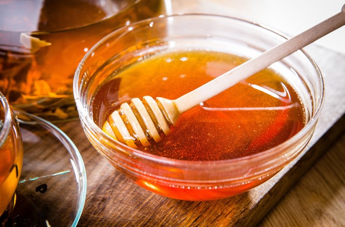 Honey in a bowl with a honey dipper