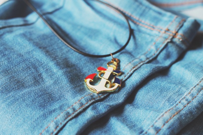 Anchor necklace on blue denim jeans